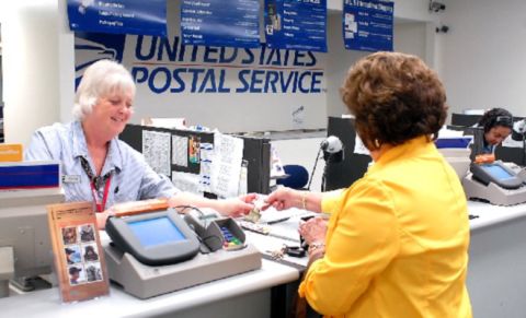 Filling out USPS PS Form 3575 at the post office.